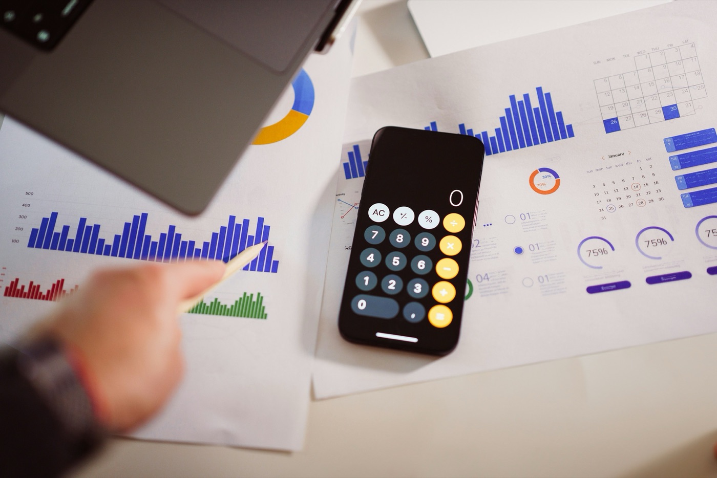 A finance desk with payroll charts, a calendar and a calculator